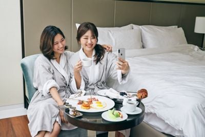 Two friends having fun with in-room dining