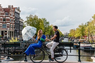 Couple cycling in Amsterdam neighborhood