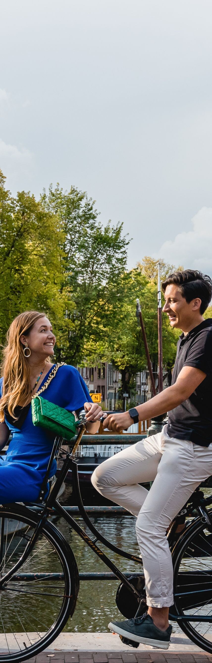 Couple cycling in Amsterdam neighborhood