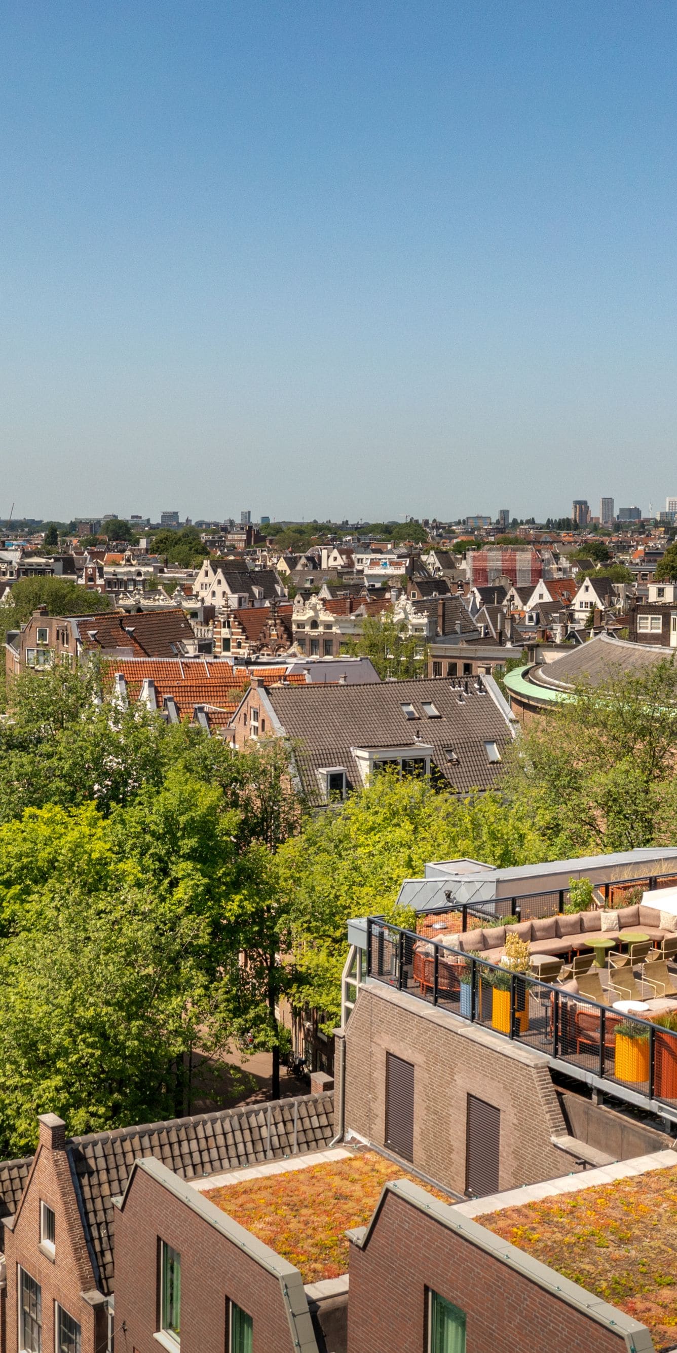 Terras van CIMA met zitplaatsen buiten en uitzicht over de stad