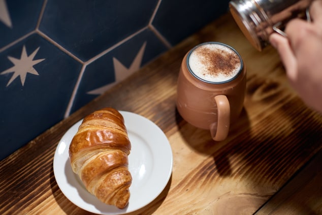 Close up image of coffee and croissant