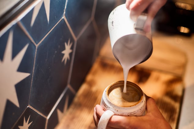 Close up image of steamed milk being poured