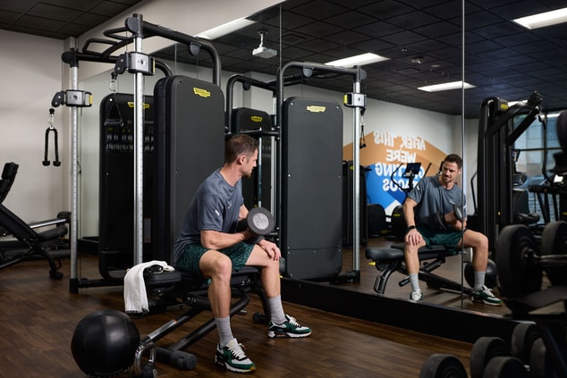 Man lifting weights in fitness room