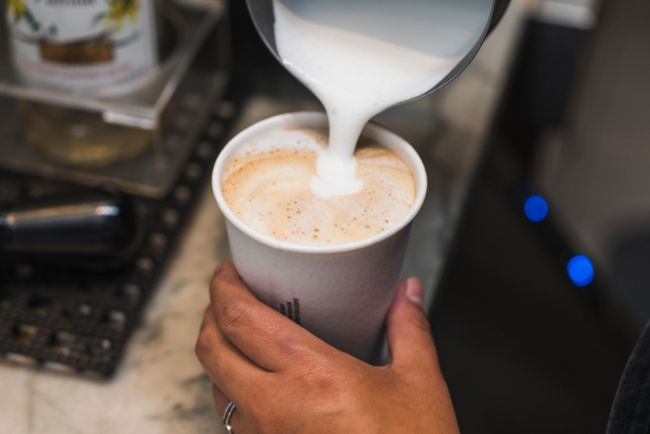 barista poruing colombe coffee into a cup