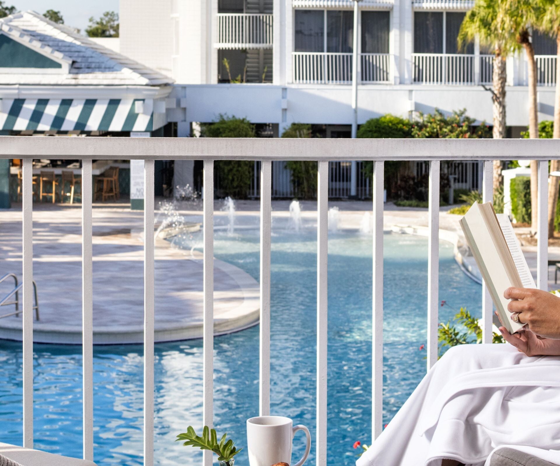 Lady reading on hotel balcony
