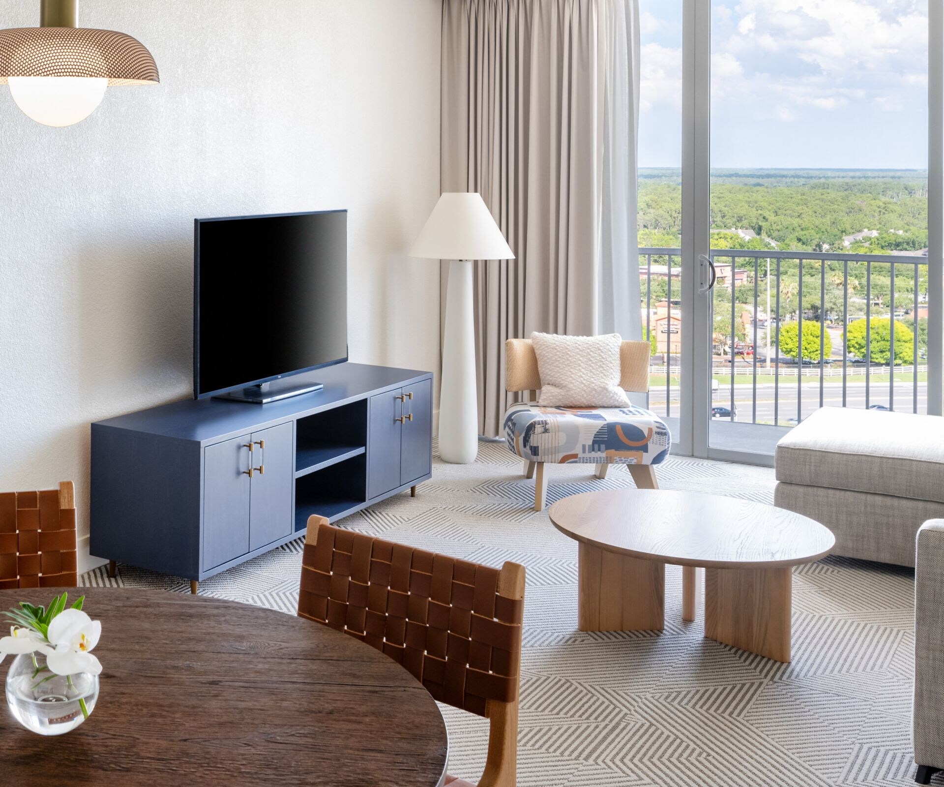 table with chairs, sofa, TV, balcony