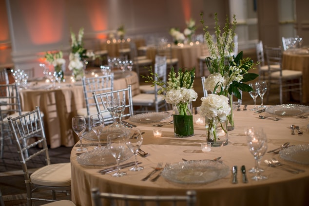Large ballroom with dining cutlery and chairs.
