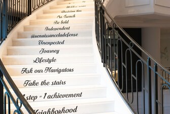 Escalier blanc avec rampe noire et messages représentant les valeurs de notre enseigne