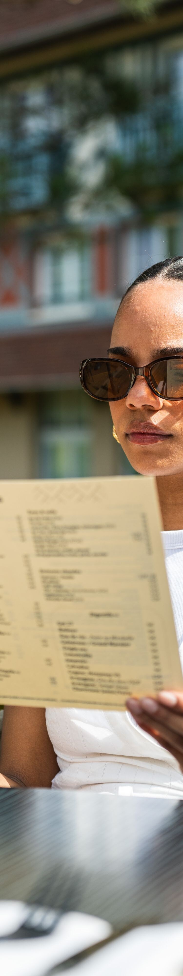 Client lisant un menu sur la terrasse du restaurant