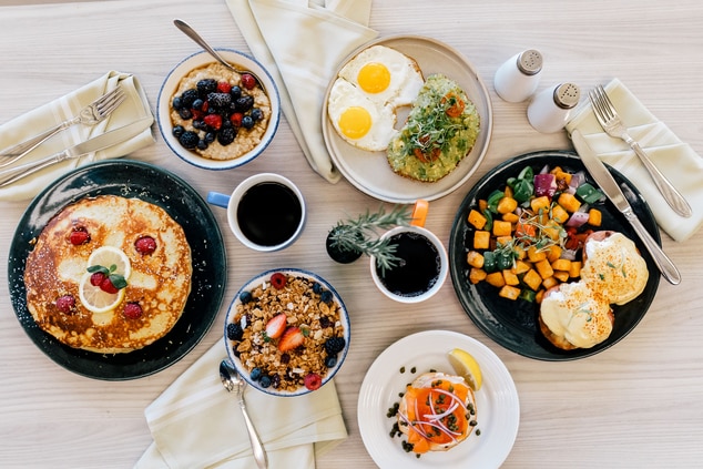 Pancakes, oatmeal and eggs on individual dishes