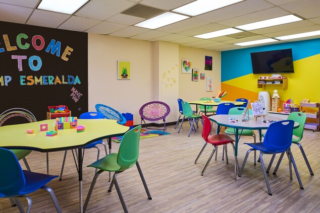 Room with kids tables and chairs, chalkboard