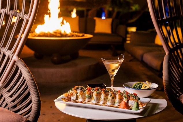 Two chairs with plate of sushi with firepit 