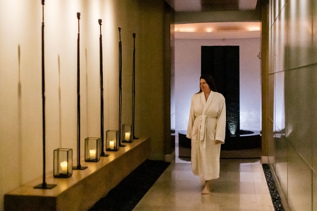 Person in spa robe walking down hallway