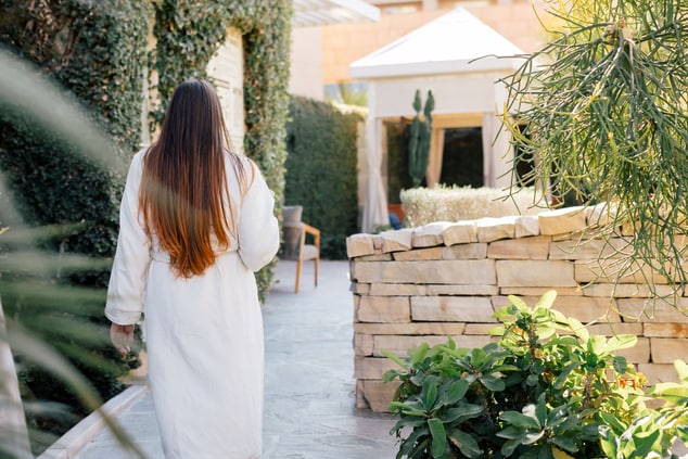 Person in spa robe walking in outside patio space