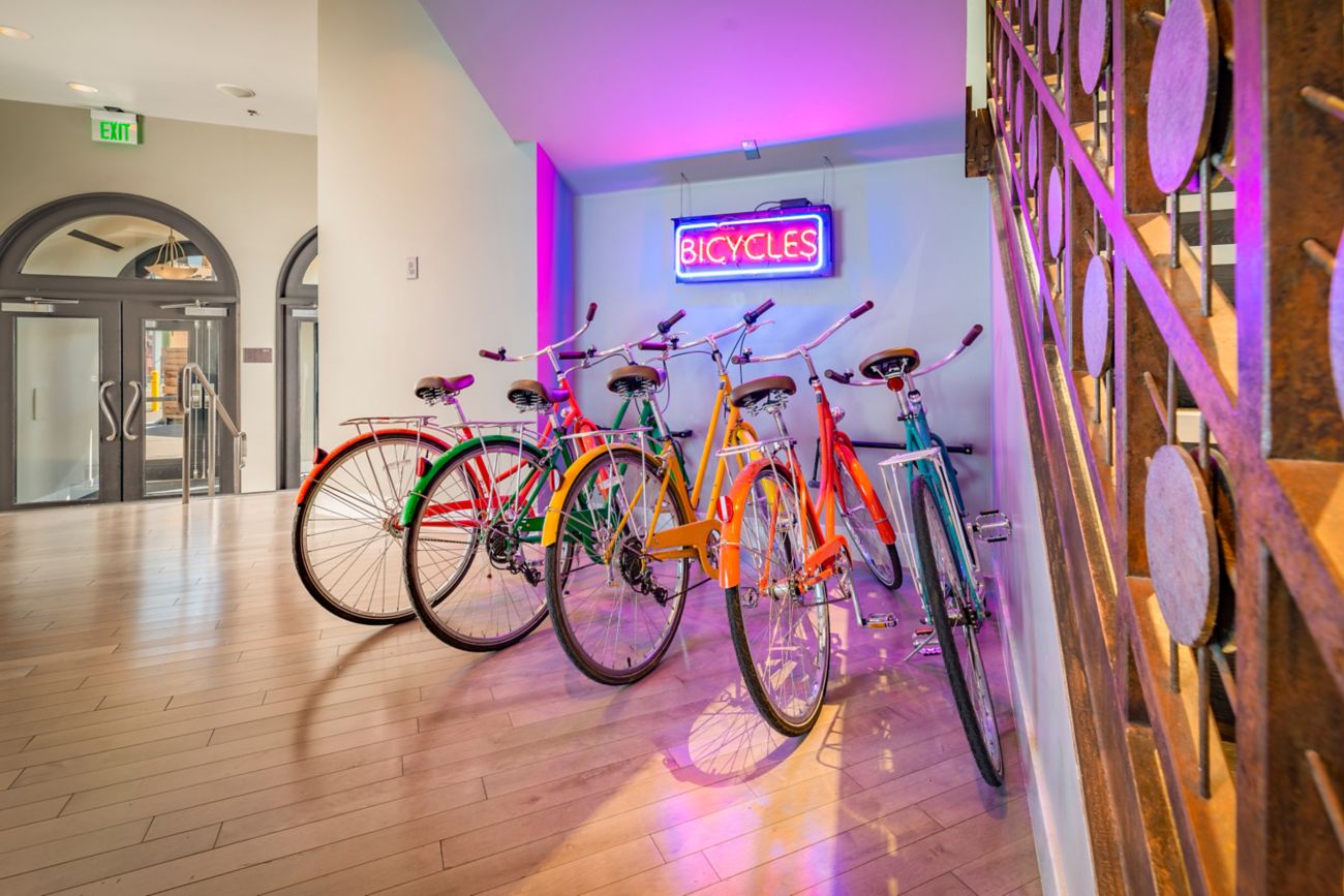 5 bikes with a neon sign above them that says "bic