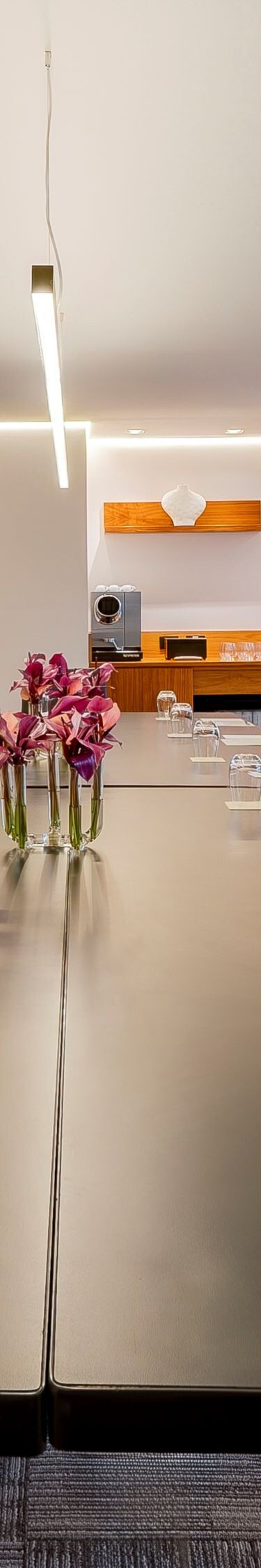 Sala de reuniões com mesa no centro, cadeiras