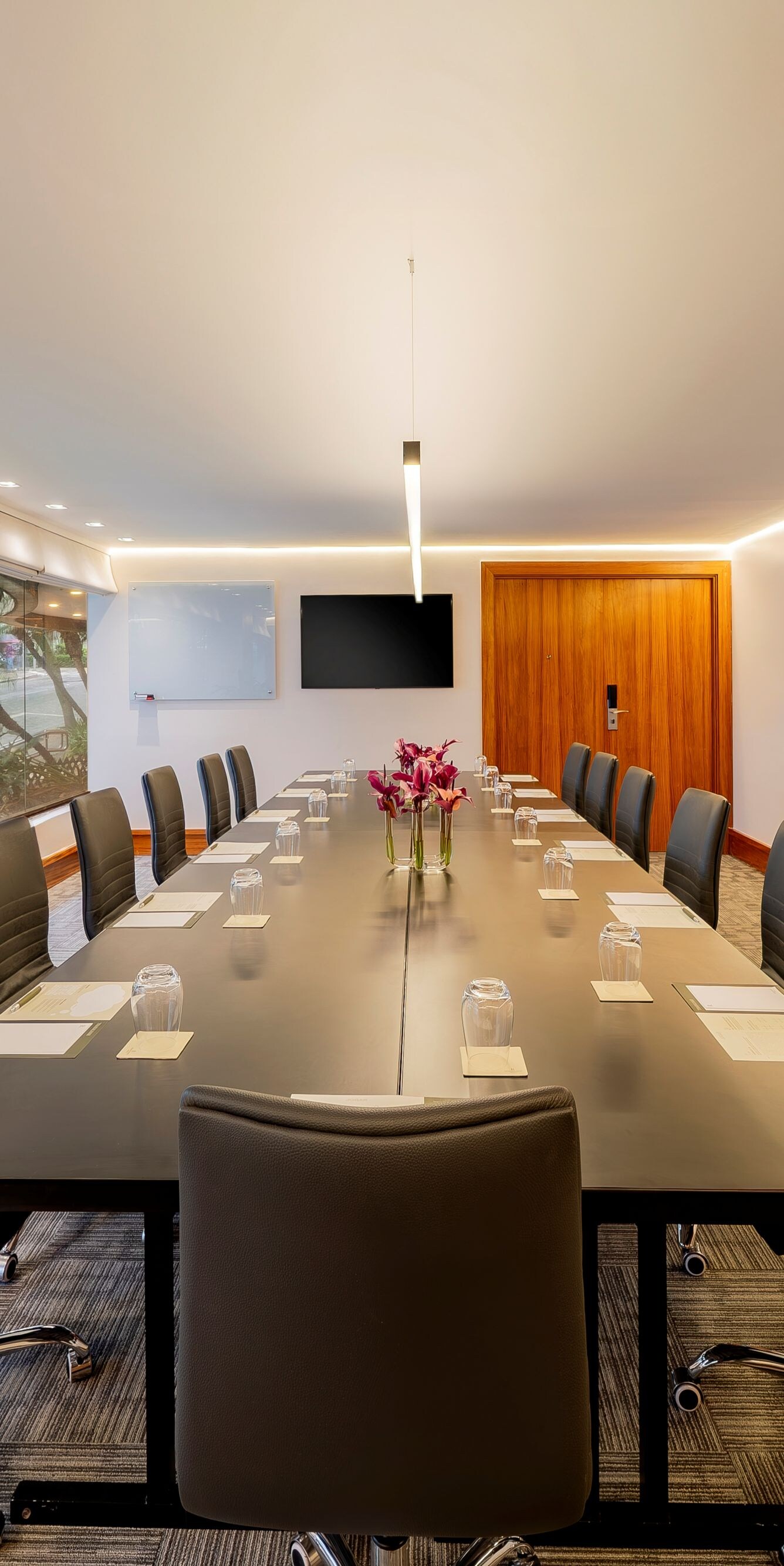 Sala de reuniões com mesa no centro, cadeiras