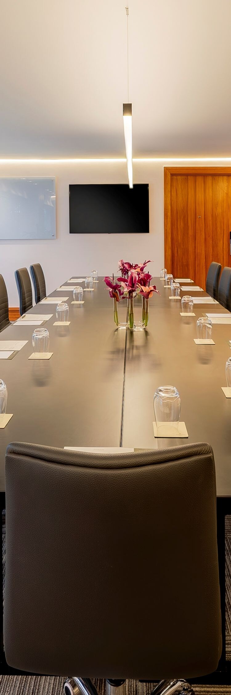 Sala de reuniões com mesa no centro, cadeiras