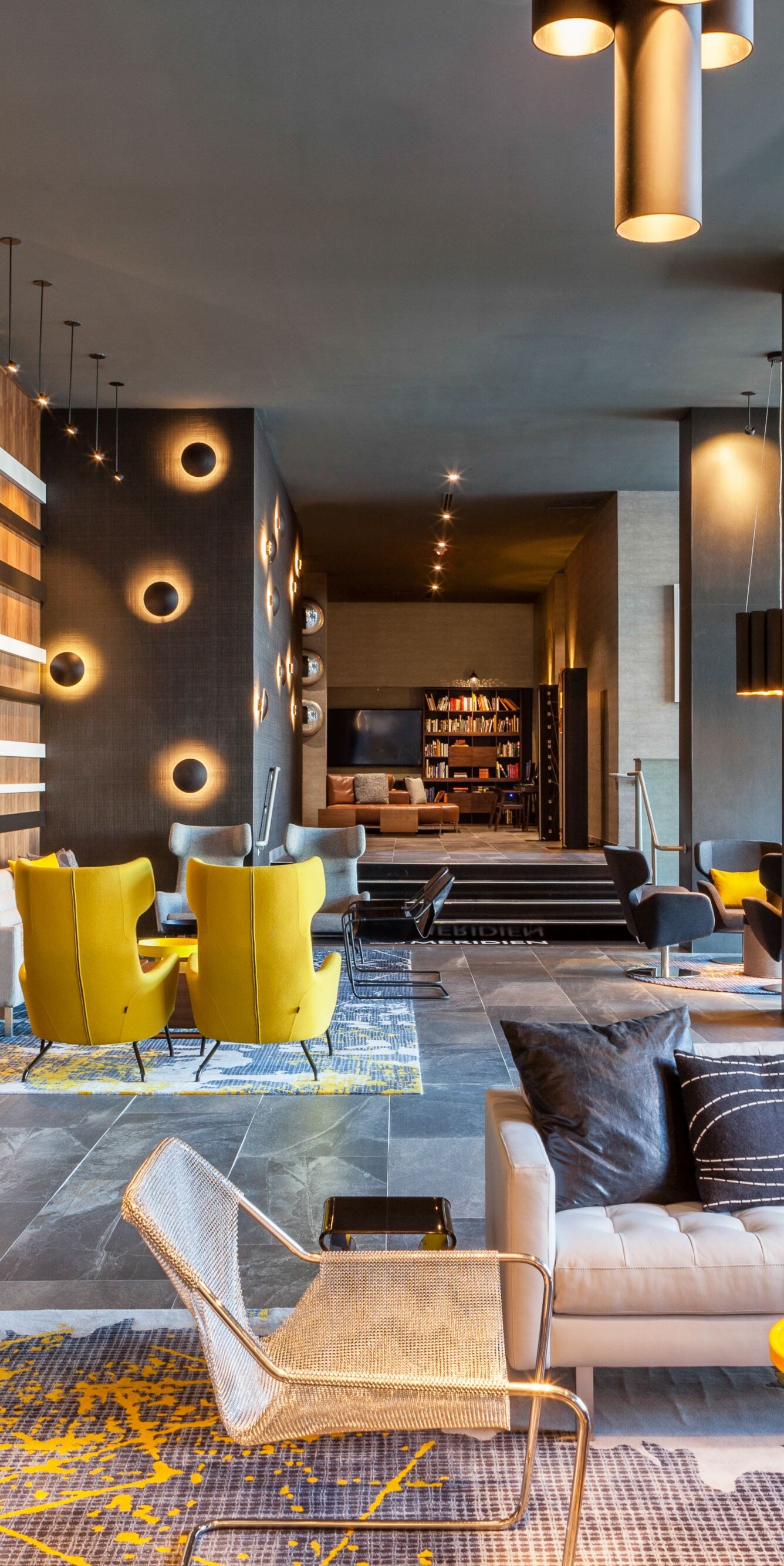 Le Méridien Charlotte lobby with modern seating, yellow accent chairs, and contemporary artwork