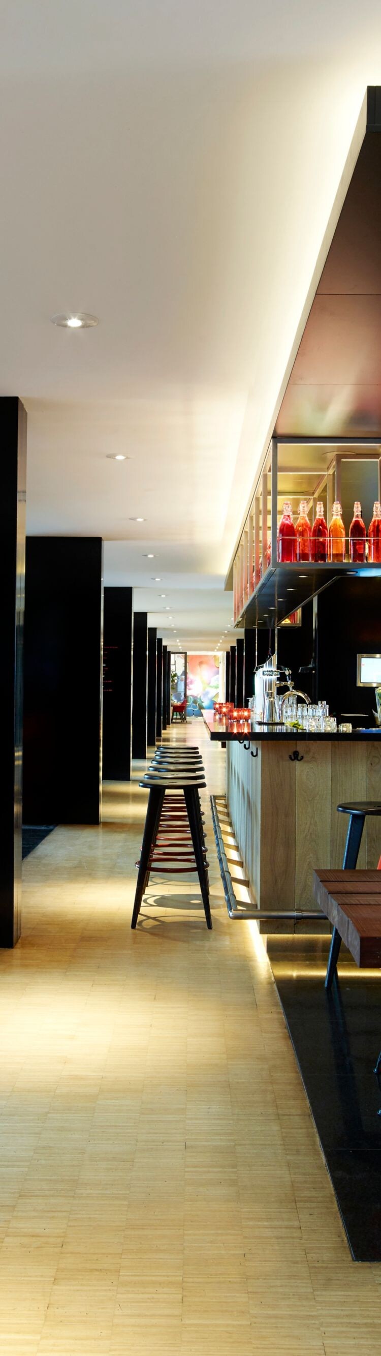 Restaurant with colorful chairs and open kitchen.