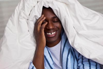 Male guest in a robe under comfy white bedding