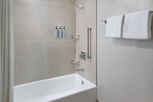Bathtub with shower head, soap and towels
