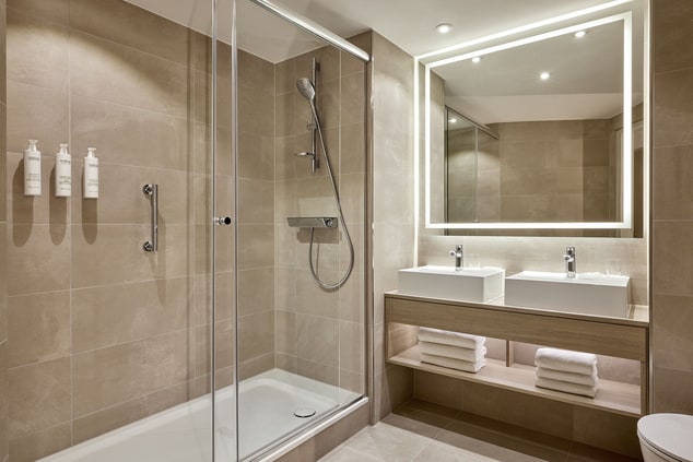 Bathroom with glass shower, two sinks and mirror