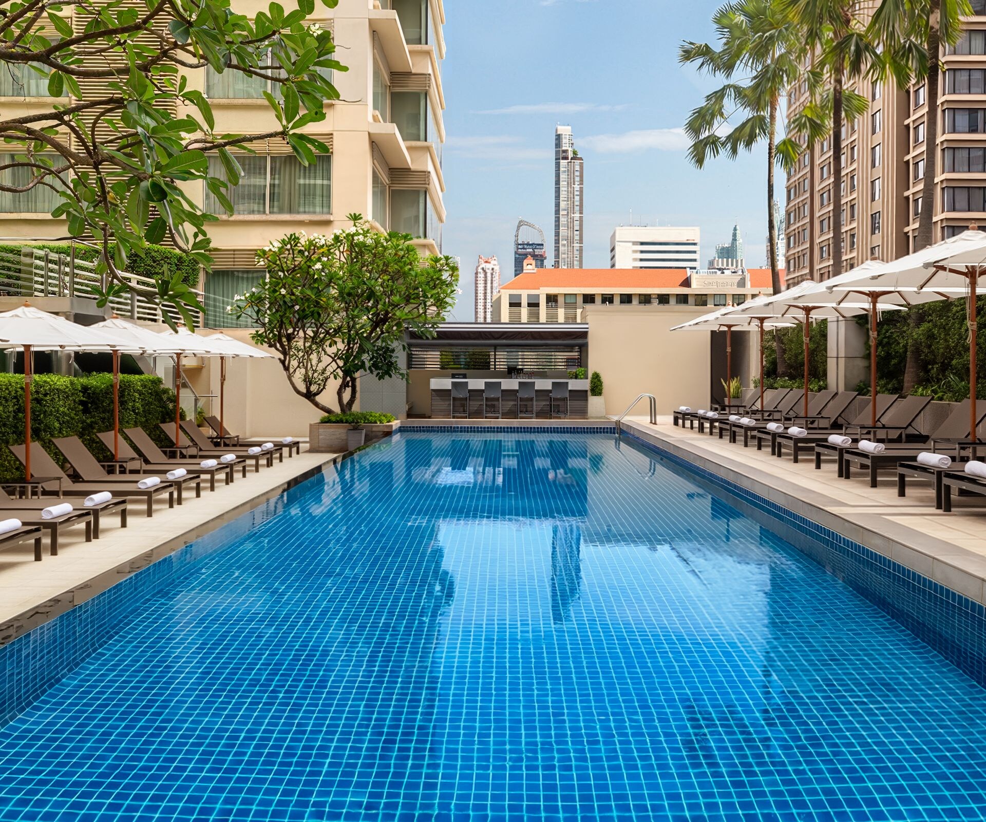 outdoor pool with sunbeds and umbrellas