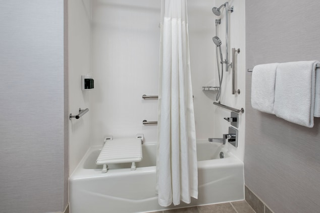 Accessible bathtub with grab bar and bench