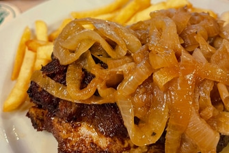 Pork chop with glazed onions and french fries