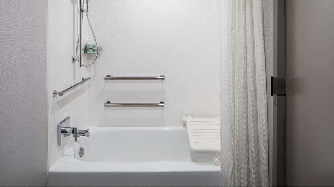 Baño con instalaciones para personas con necesidades especiales con barras de apoyo.