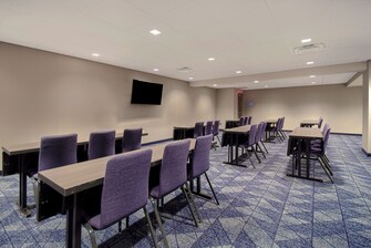 conference room with tables, chairs and tv
