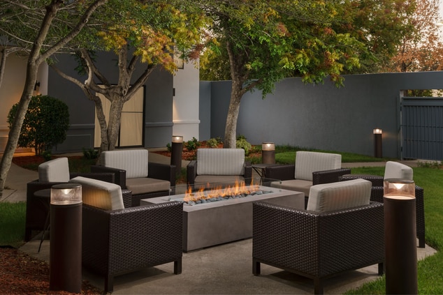 Outdoor patio chairs with firepit in the center.