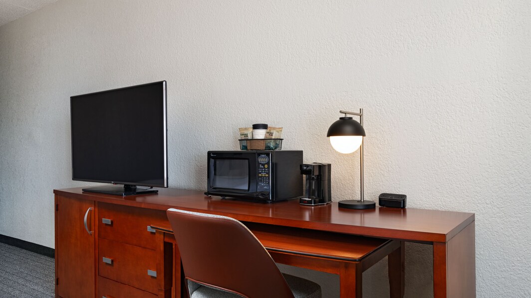 desk area, tv, chair, microwave, lamp, coffee