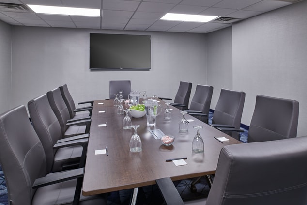 meeting room, chairs, large table, tv, water