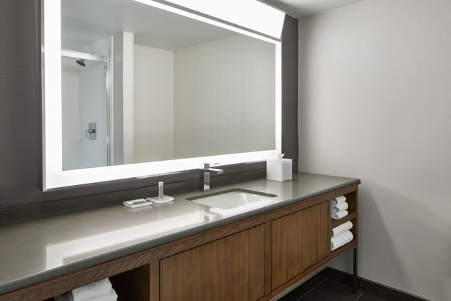 large mirror, counter, bathroom vanity, towels