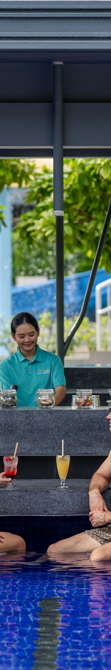 คู่รักกำลังพักผ่อนที่บาร์ริมสระว่ายน้ำของรีสอร์ท