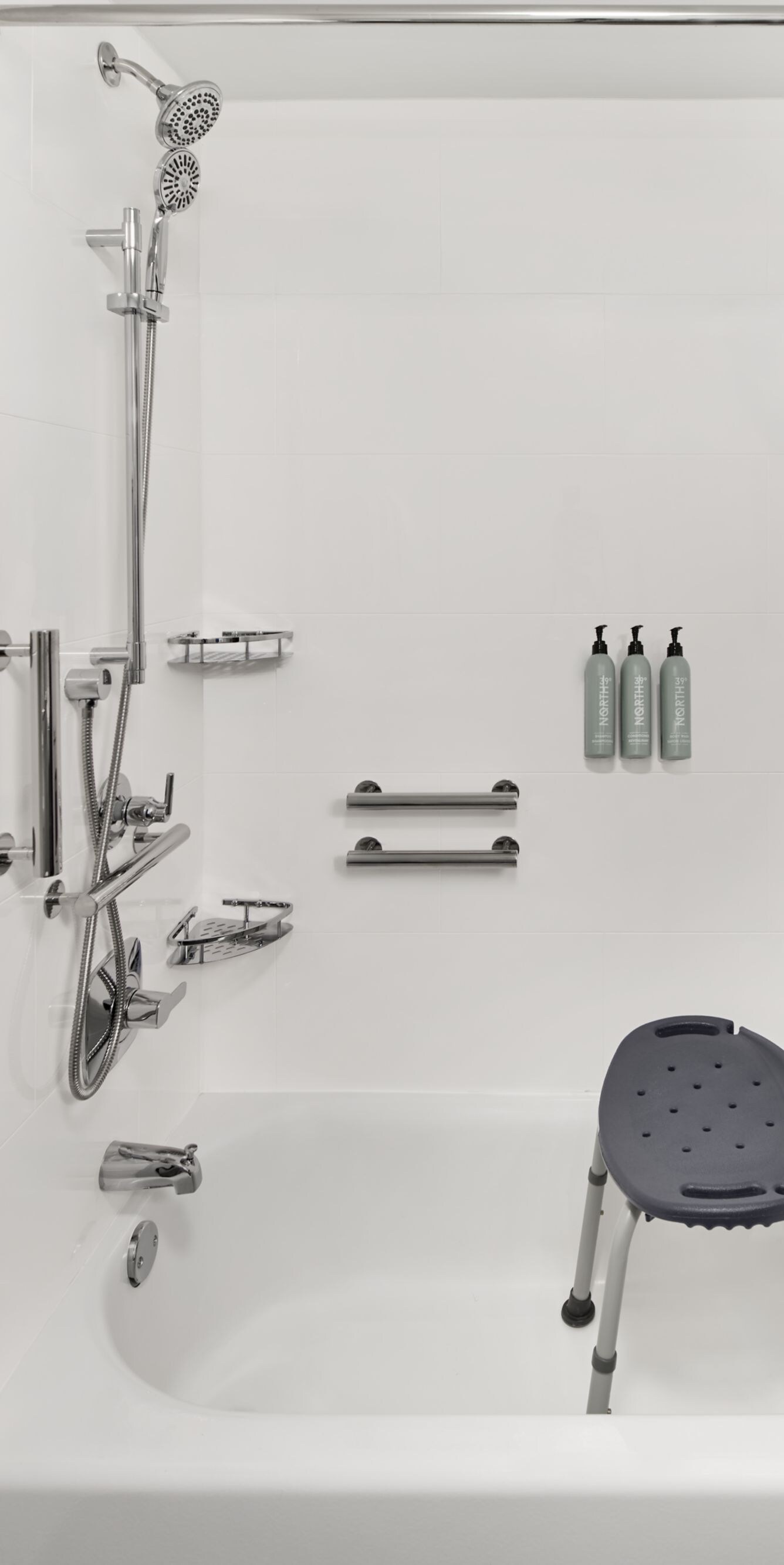 Shower‑tub with grab bars and a shower chair