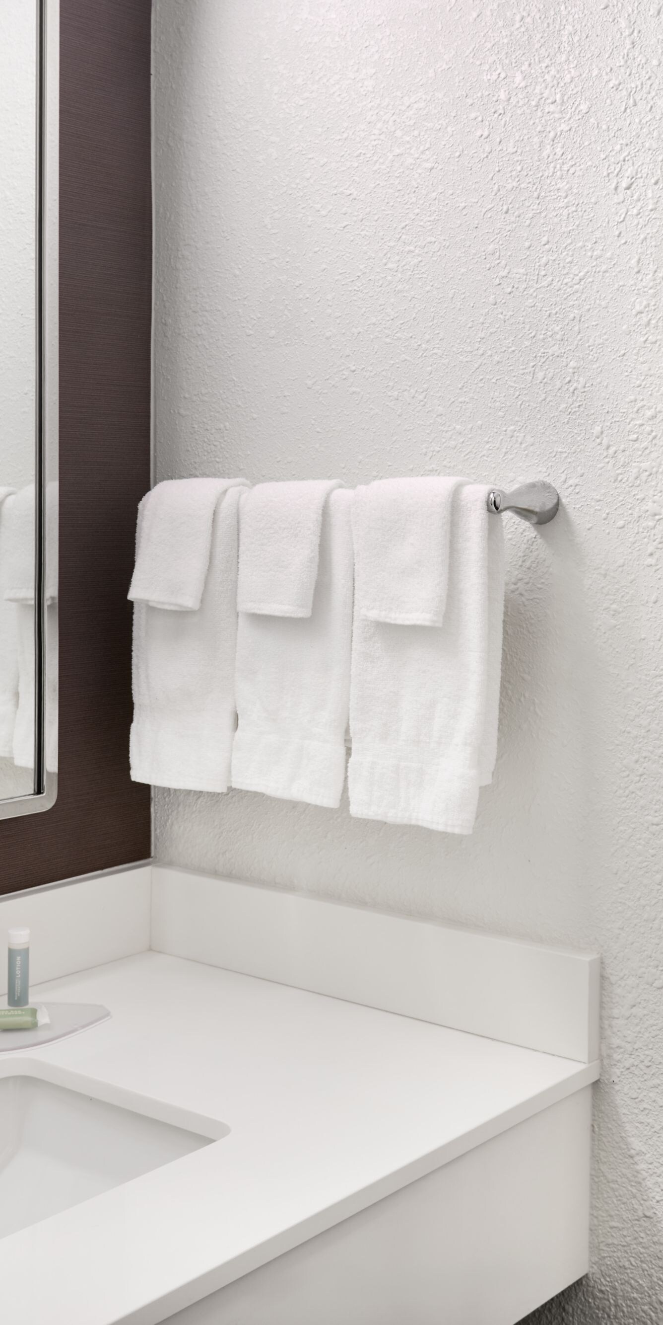 Vanity with sink and towels beside shower‑tub comb