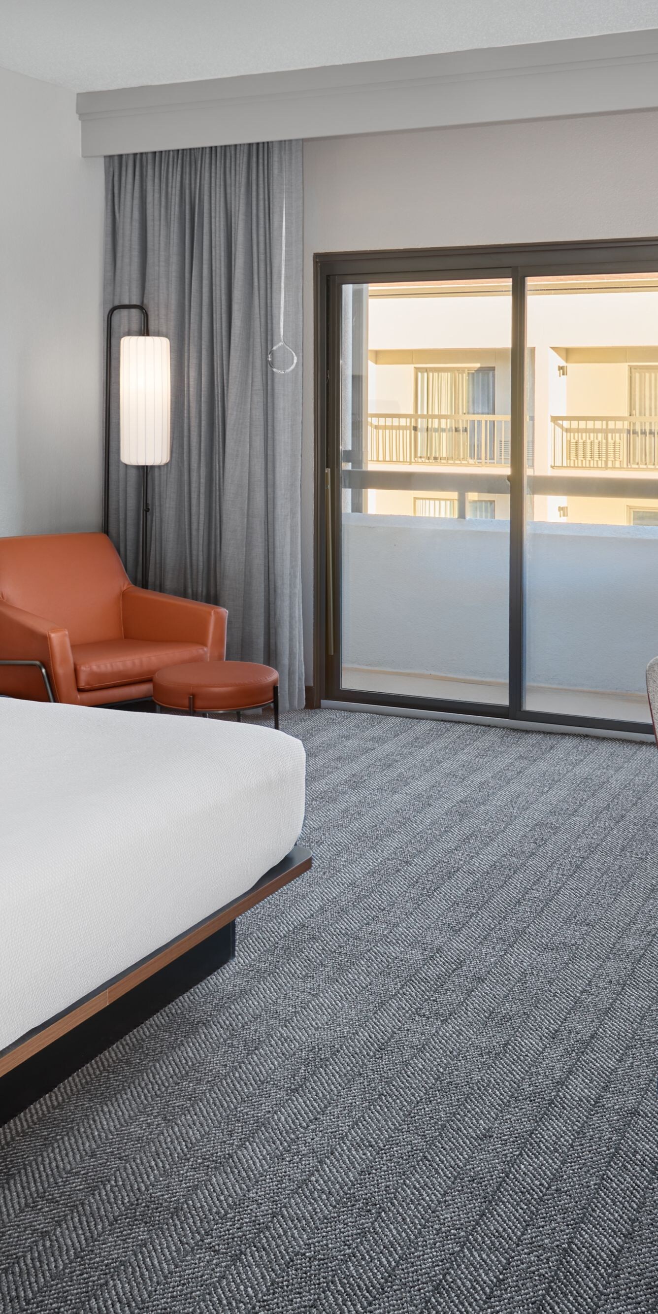 King bed with desk, chair, and balcony view