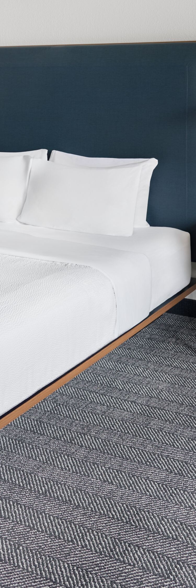 king bed, orange armchair, ottoman, and lamp