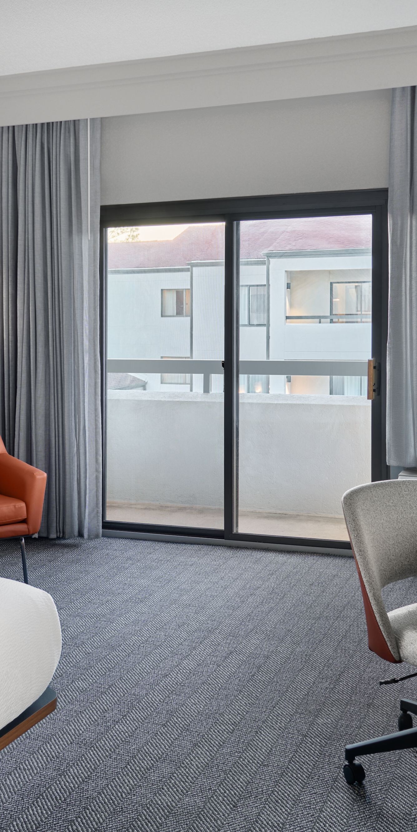 King bed with desk, chair, and balcony view