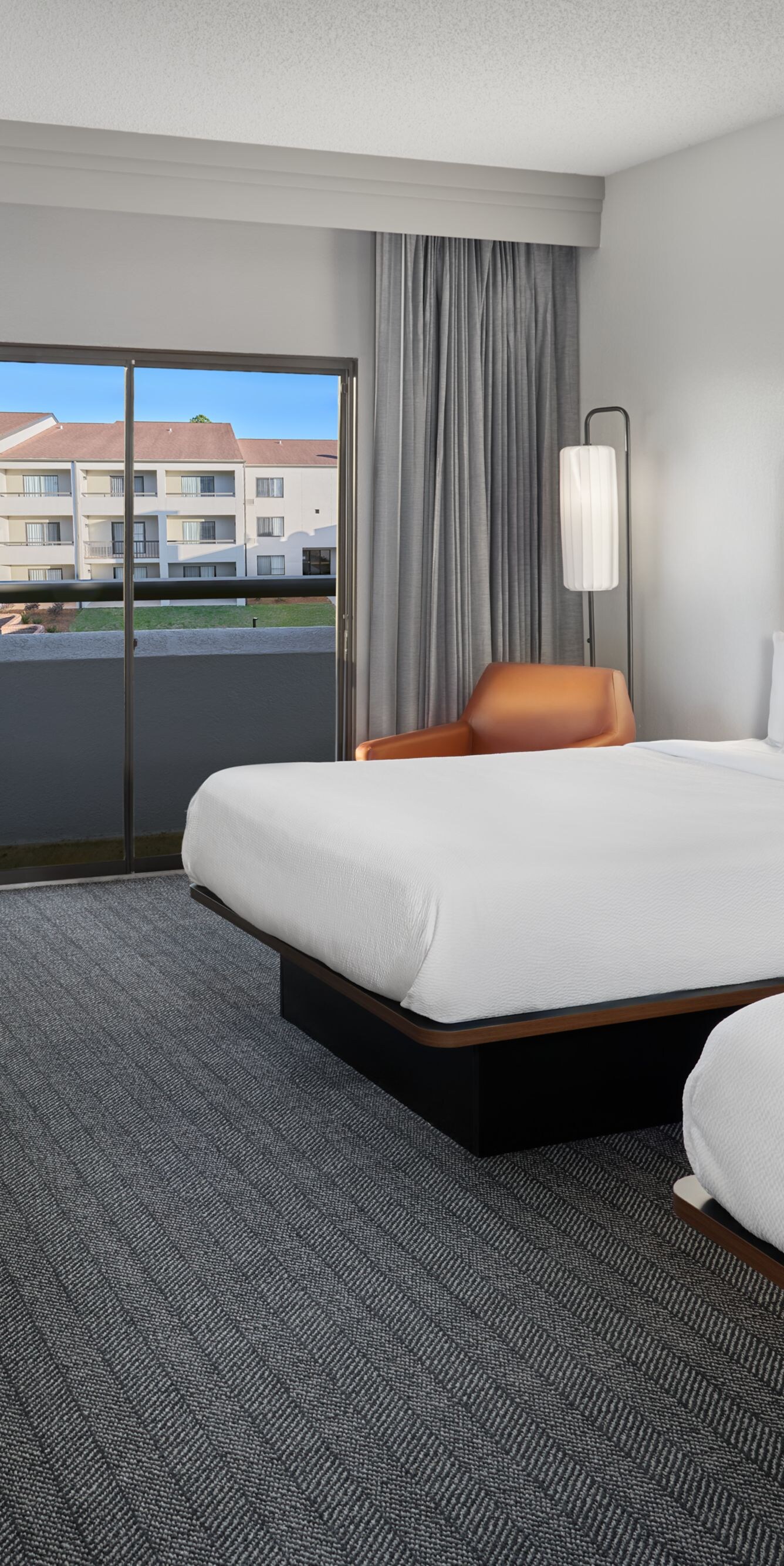Two queen beds with desk and balcony view