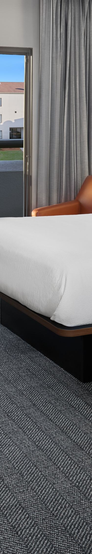 Two queen beds with desk and balcony view