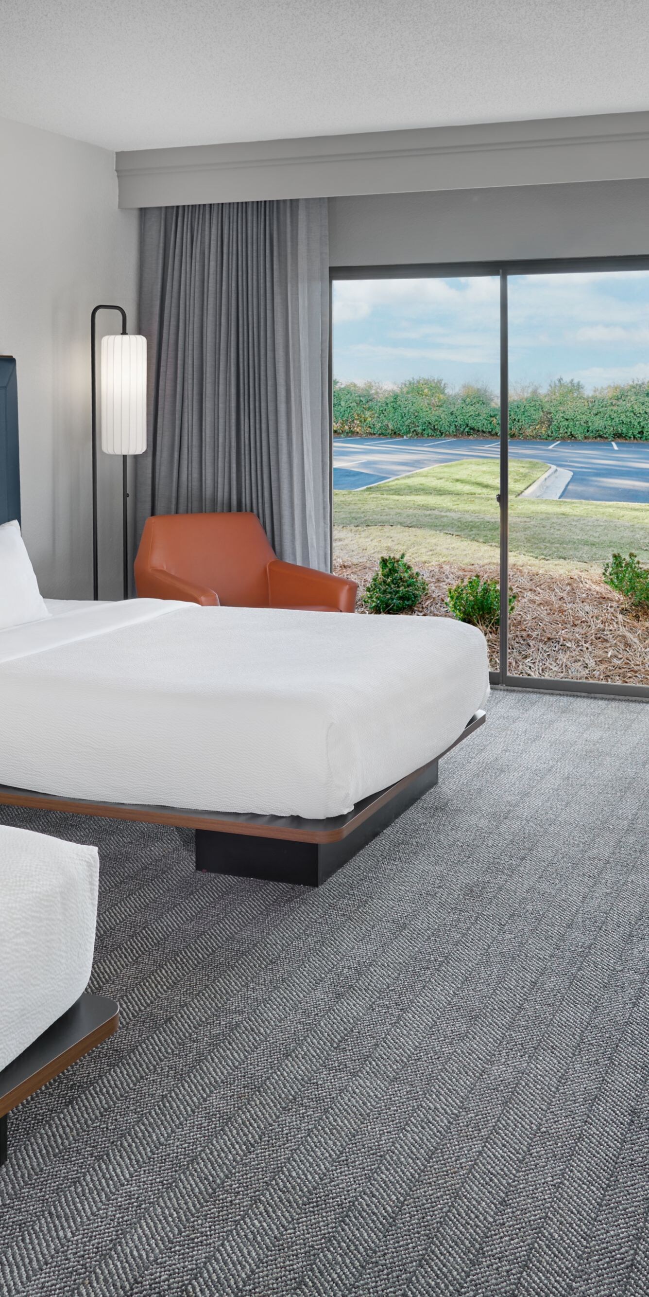 Two queen beds with desk, chair, and patio door 