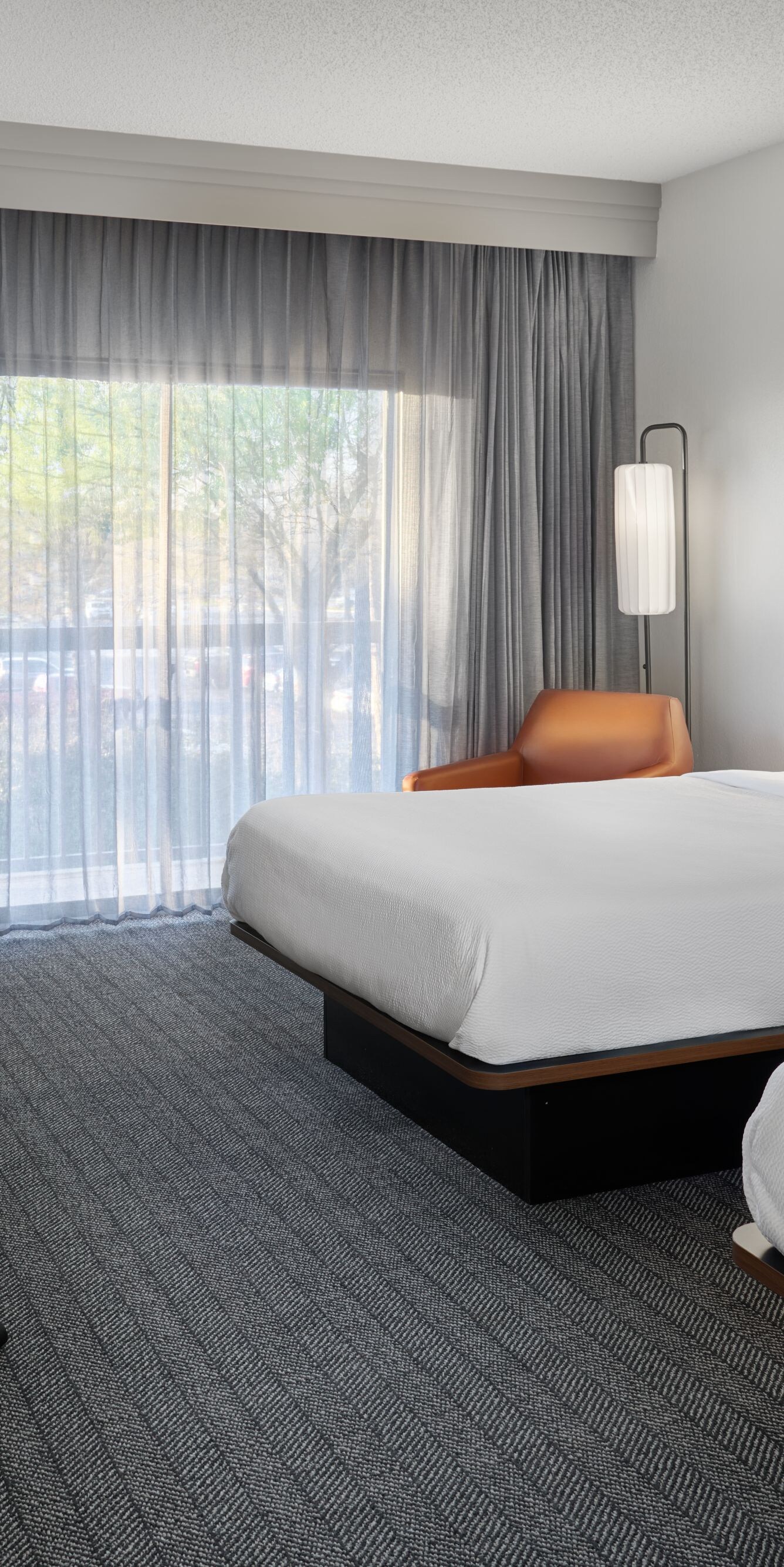 Two queen beds with desk and chair by window