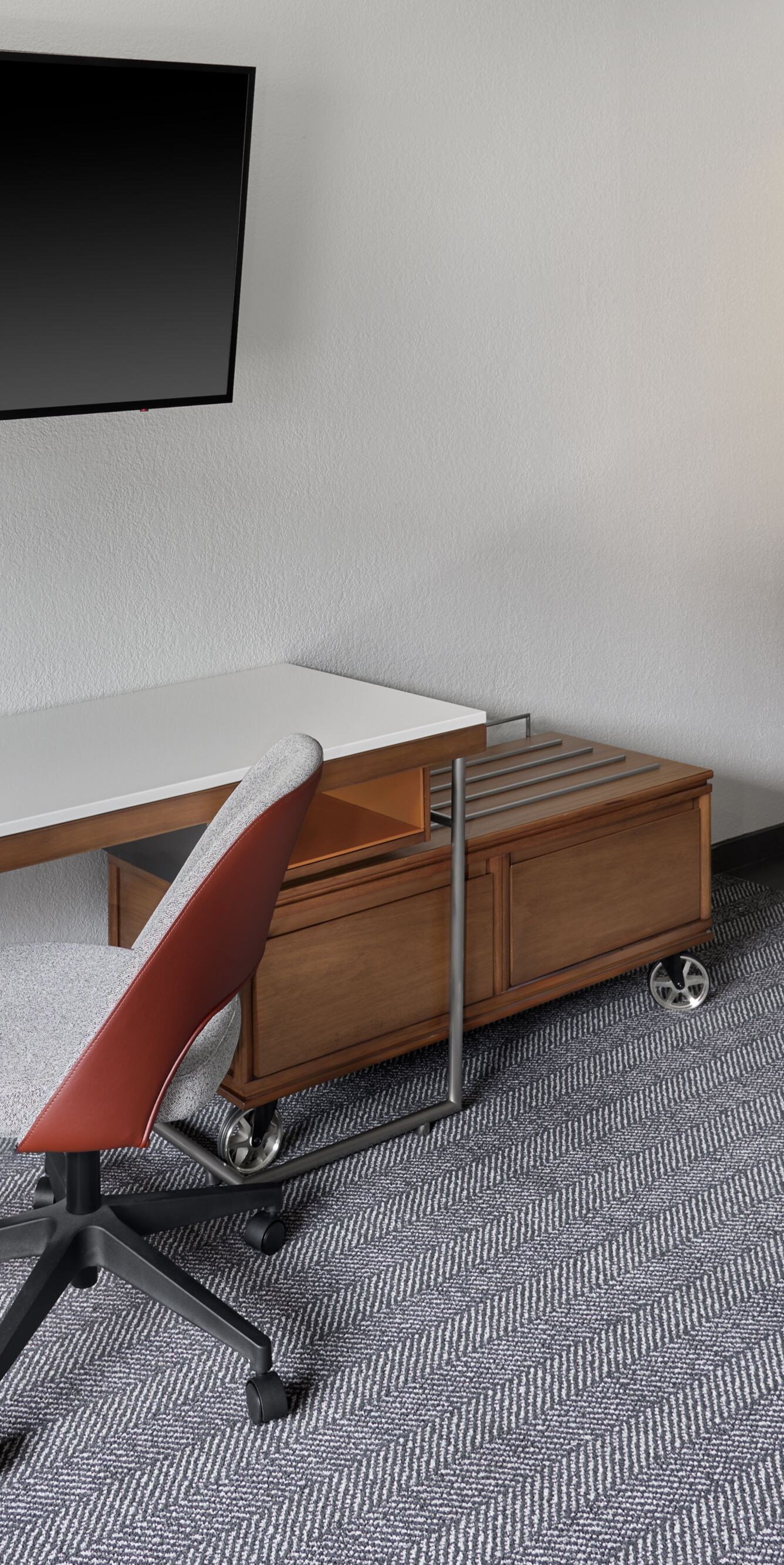 Desk with chair, wall TV, and kitchenette area