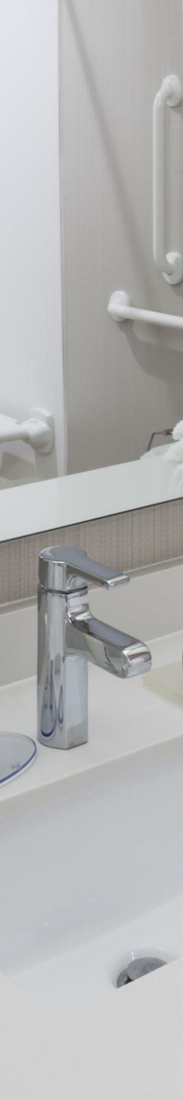Roll-in shower in reflection of mirror over vanity
