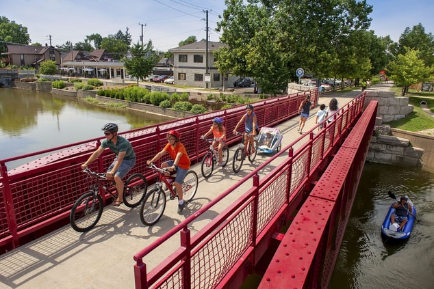 family riding bikes on a bridge