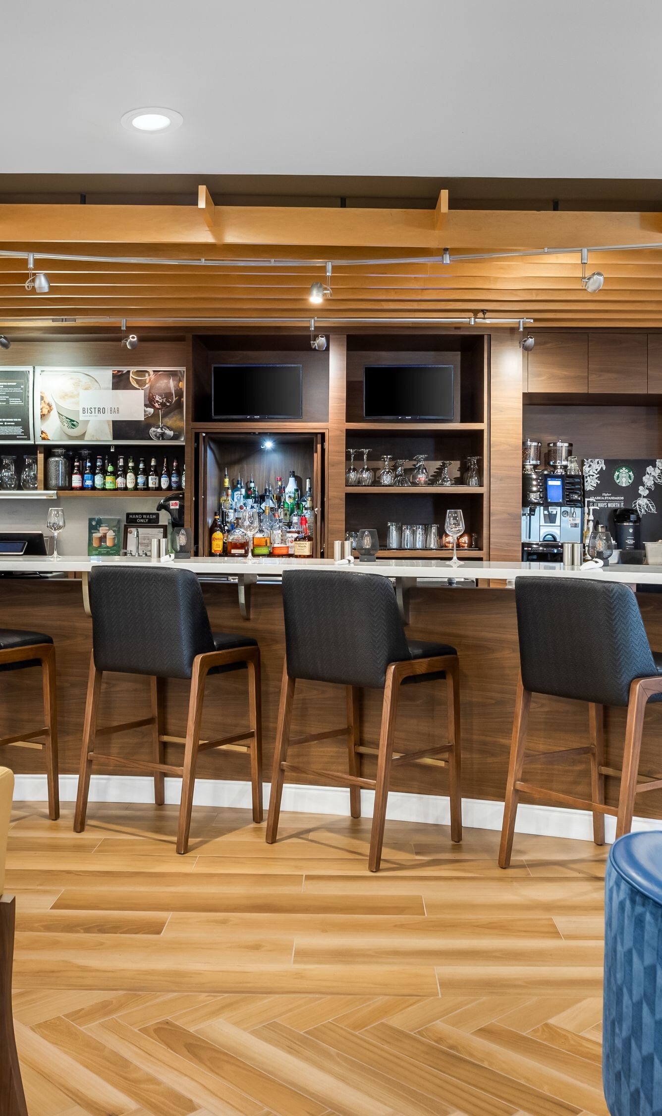 Hotel lobby bar with wood accents and stools